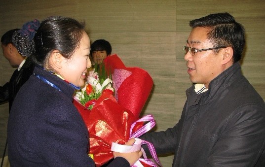 國航西南客艙部總經(jīng)理張宏為楊晉萍乘務(wù)長(cháng)送上鮮